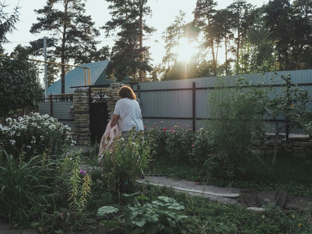 woman in white dress standing near green plants during daytime