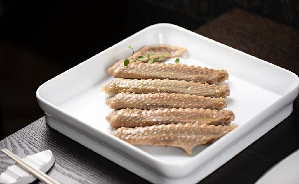Refined presentation of cooked oriental chicken wings on a white dish, perfect for a dining setting.