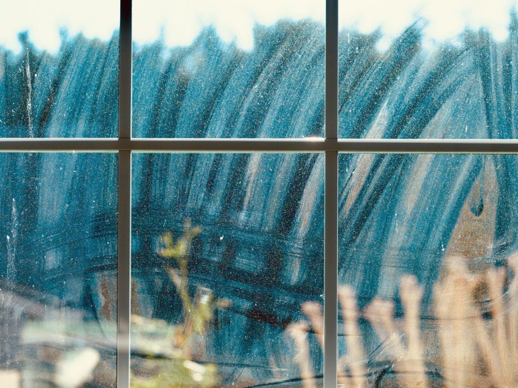 Abstract blue and white streaks on a window pane.