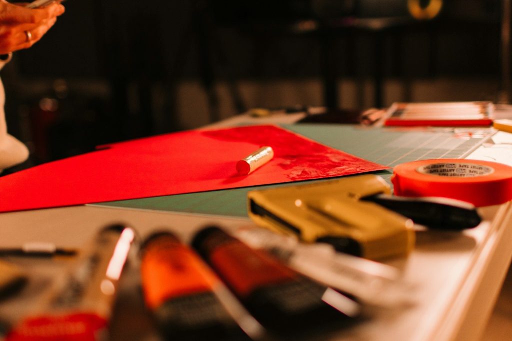 Art supplies on a table with red paper