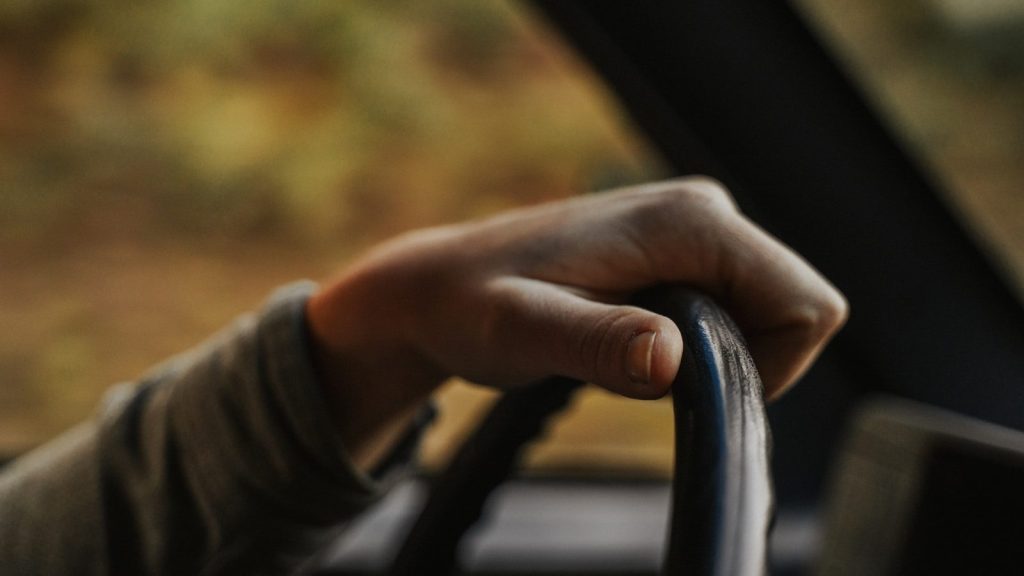 man holding steering wheel