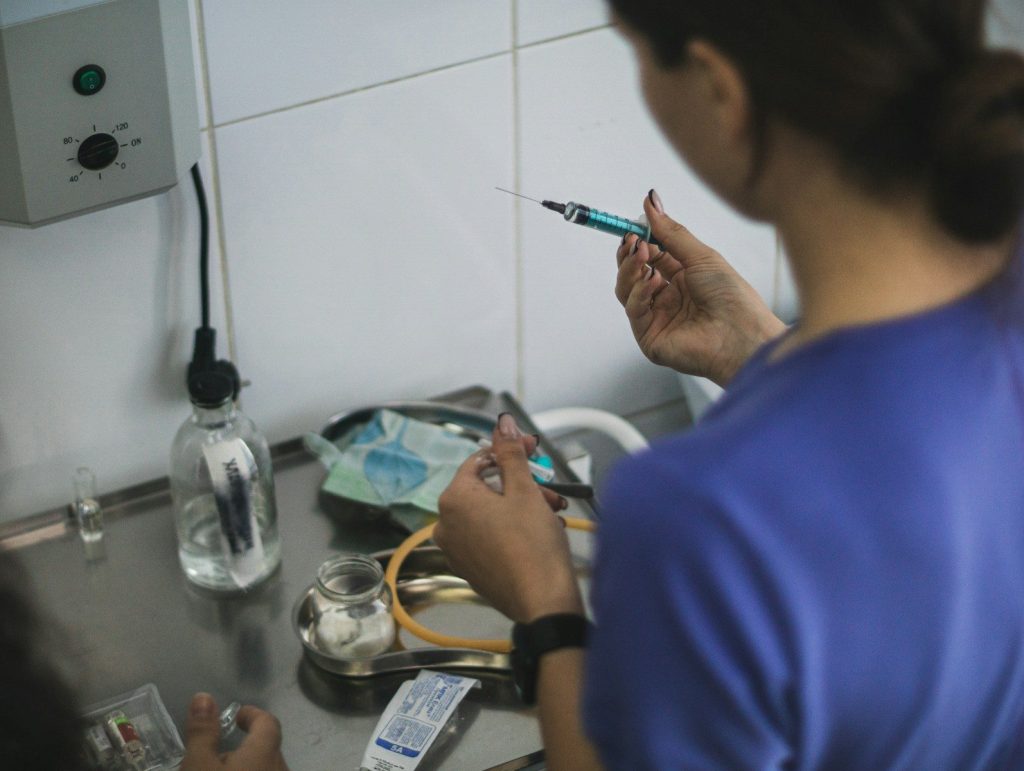 A person preparing a syringe with blue liquid.