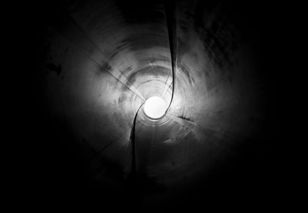 A captivating black and white abstract view inside a pipe, creating a tunnel effect.