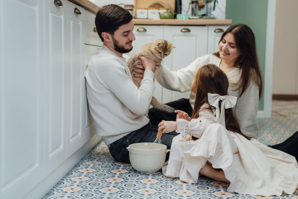 Family enjoying quality time in kitchen with their cat. Cozy indoor scene.