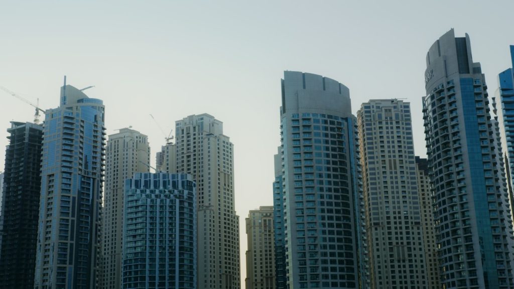 A city skyline with modern skyscrapers under a clear, bright sky.