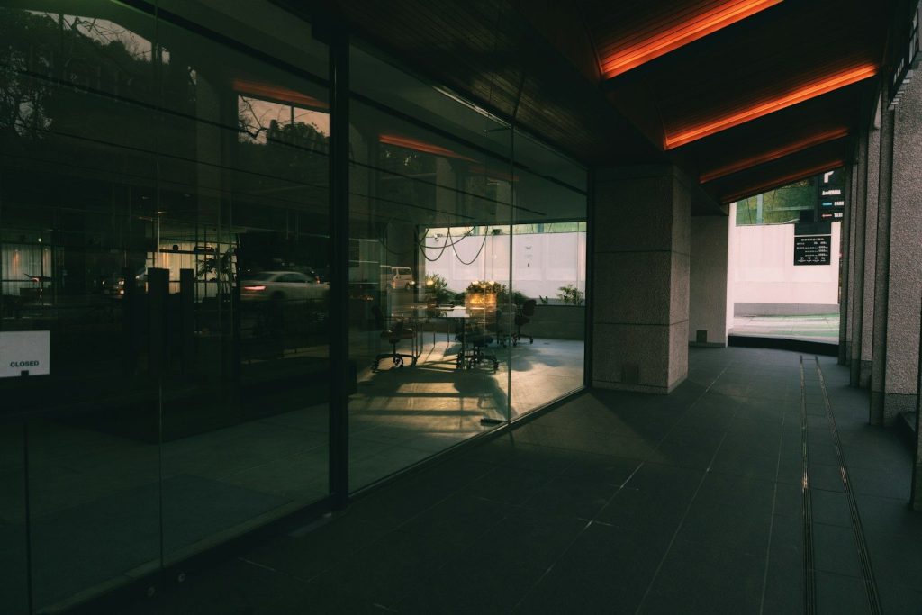 Modern building exterior with large glass windows and orange lights.