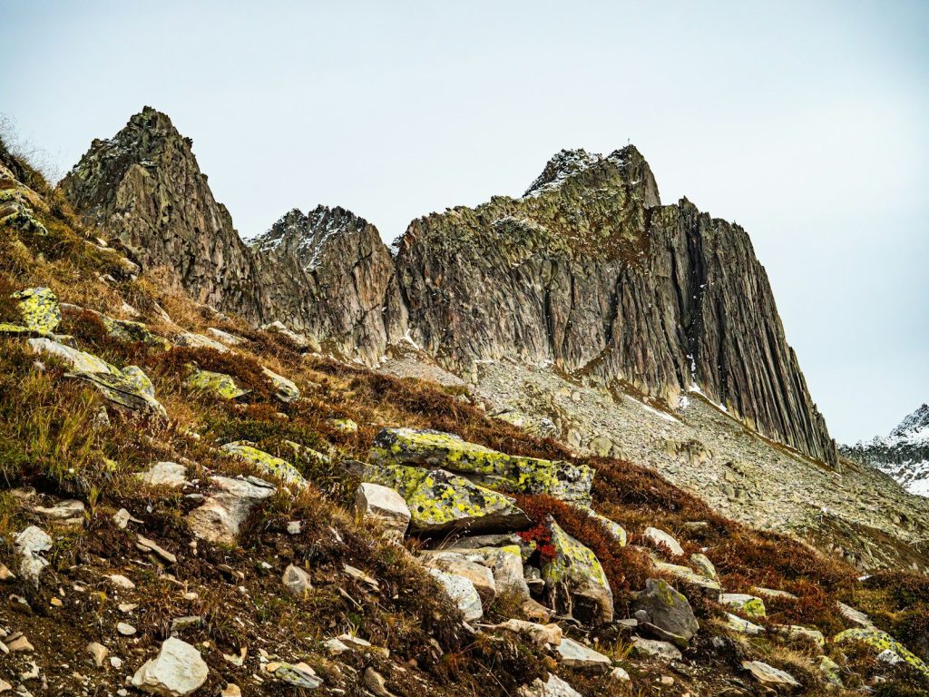 Jagged mountain peaks rise above rocky, grassy terrain.