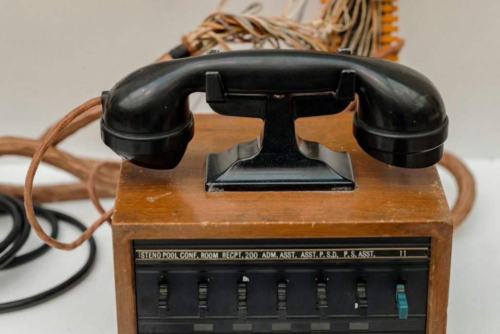 an old fashioned telephone sitting on top of a wooden box