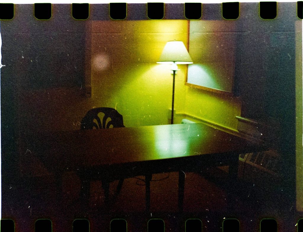 A desk and chair illuminated by a lamp.