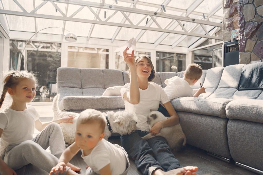 A joyful family with children and pets having fun indoors, enjoying leisure time together.