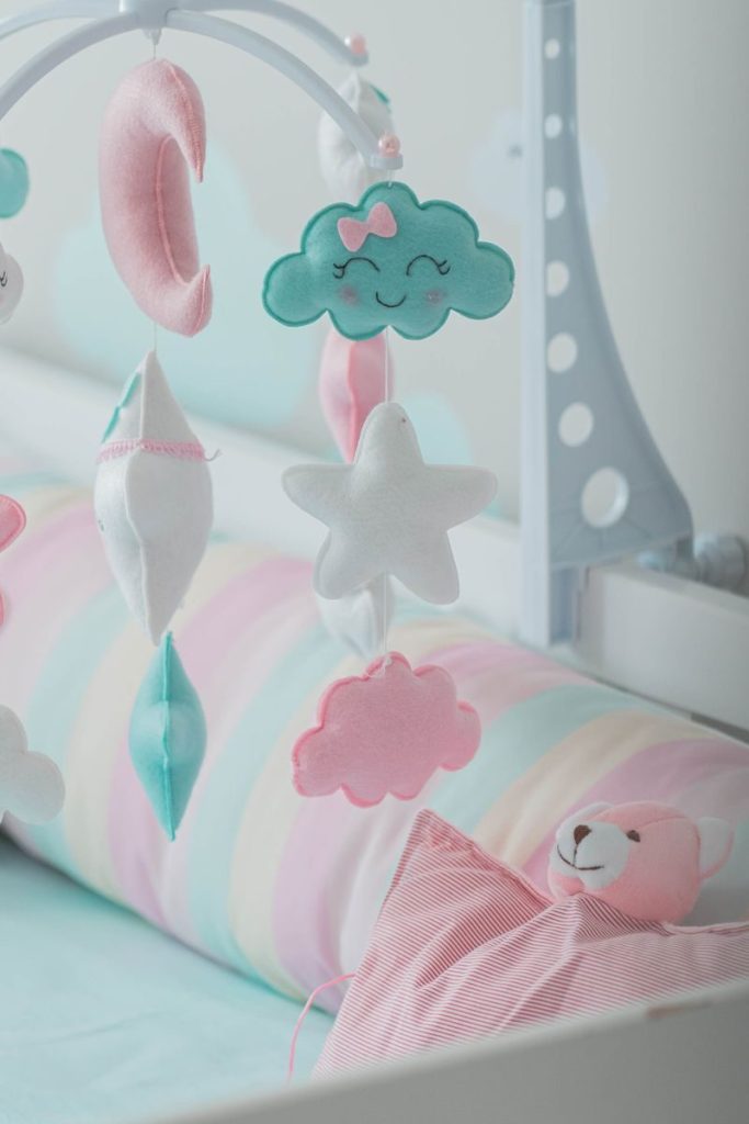 Pastel-themed nursery with a cute mobile and toys, creating a cozy baby atmosphere.
