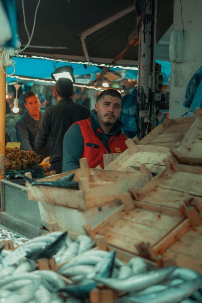 A vibrant scene at a fish market in Bursa, Turkey, capturing vendors and fresh seafood.