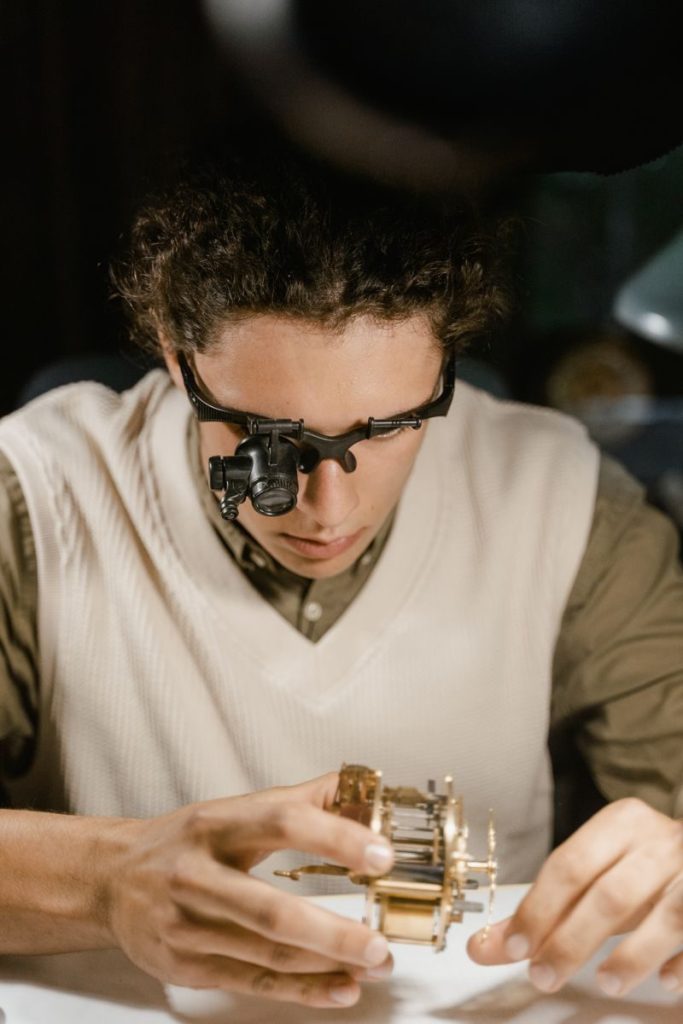 Young watchmaker meticulously repairs a delicate timepiece, focusing intently on the intricate details.
